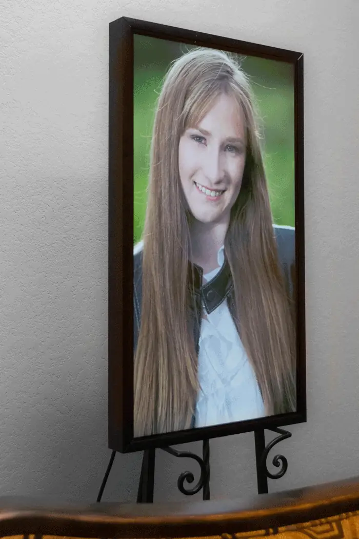 A Nimbus frame standing on an easel on a mantel, displaying a portrait photograph